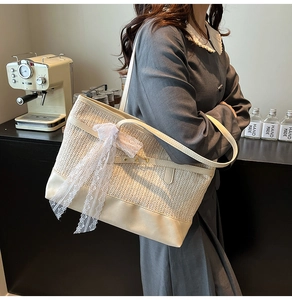 Detail of woven straw tote bag featuring white lace bow and elegant herringbone texture