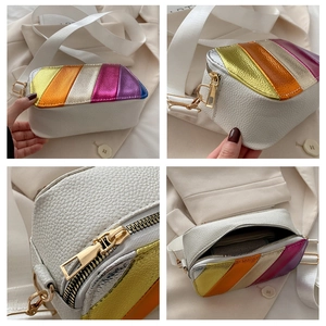 Detail view of white pebbled leather handbag with colorful metallic stripes and gold hardware