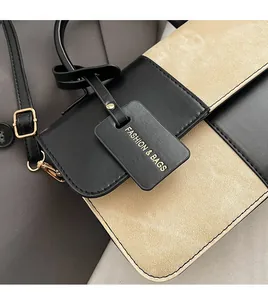 Close-up of contrast black and beige PU leather bag with litchi texture and fashion tag