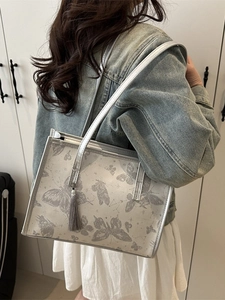 Silver butterfly tote bag with long tassel and star patterns for fashion commuters