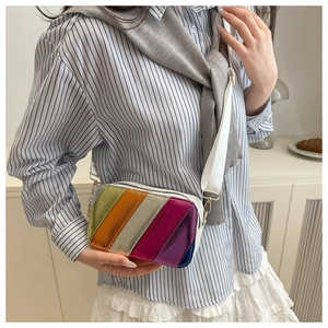 Détail du sac à bandoulière rayé multicolore avec texture grainée et large sangle blanche
