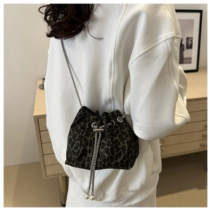 Detail of leopard print bucket bag featuring pearl drawstring accents and silver chain
