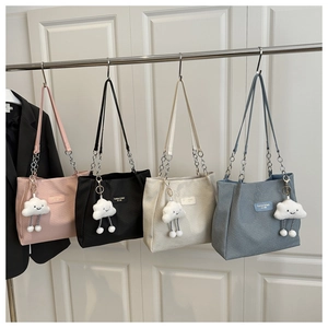 Detailed row of corduroy tote bags in four colors with chain straps and cloud charms