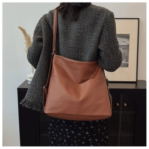 Close-up of brown litchi pattern tote bag showing high-quality leather texture and strap
