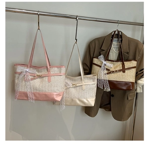 Detail of straw tote bags with leather straps and delicate white lace bows