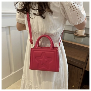 Detail of fuchsia square bag with embossed star pattern and gold metal hooks