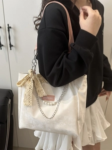 Sac fourre-tout blanc moumoute avec anses roses et nœud en dentelle porté par femme