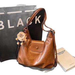 Brown vintage hobo shoulder bag with magnetic flap pocket and plush charm accessory