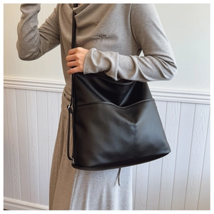 Detail of black pebbled leather hobo bag with adjustable strap and front pocket