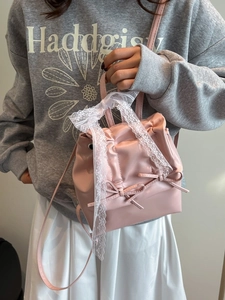 Zaino rosa stile balletcore con fiocchi e pizzo indossato da una modella femminile