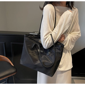 Seitenansicht der schwarzen Nylon-Einkaufstasche am Model, minimalistisches Design mit viel Platz