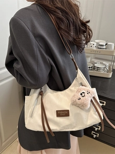 Borsa tote minimalista in nylon beige con tracolle in pelle marrone e ciondolo cane