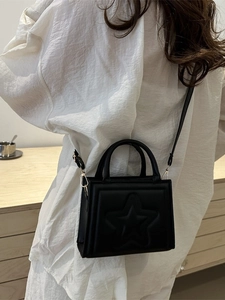 Fashionable black mini square bag with embossed star detail and dual top handles
