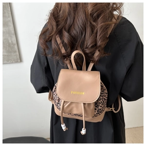 Detailed back view of a khaki and leopard print mini backpack with drawstring and metal ring