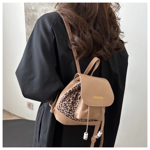 Detail view of mini beige leather drawstring backpack with leopard print side panels