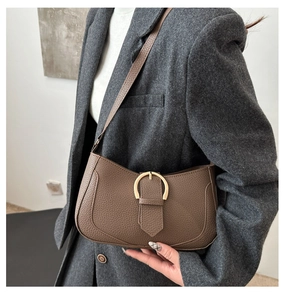 Detail einer dunkelbraunen Hobo-Tasche aus genarbtem Leder mit goldener Schnalle