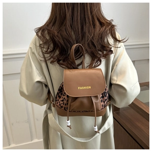 Detail of mini leather backpack featuring leopard print sides and fashion text flap