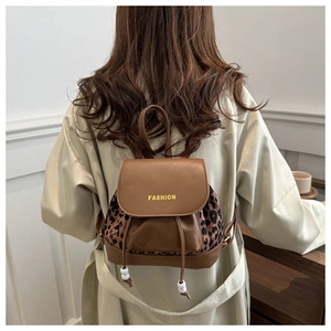 Detail of mini brown leather backpack with leopard print sides and drawstring closure