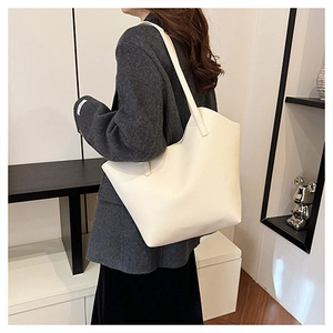 Detail of white leather tote bag with lychee texture and high-quality stitching