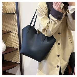 Large black lychee pattern leather tote bag styled with a trench coat for a chic office look