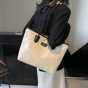 Minimalistische beige Tragetasche mit großer Kapazität und schwarzen Lederriemen