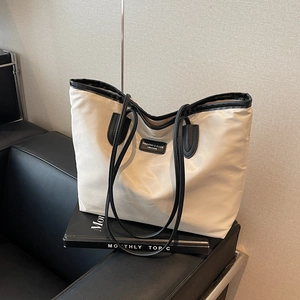 Minimalistische große cremefarbene Tragetasche mit schwarzem Besatz und Schultergurt