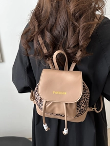 Mini khaki backpack with leopard print side panels and white bead drawstrings on a model
