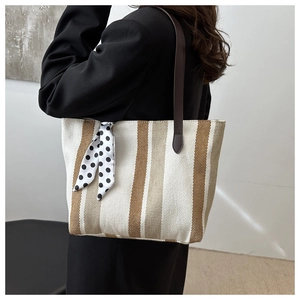 Detailansicht einer gestreiften Canvas-Tasche mit gepunktetem Halstuch und Lederriemen
