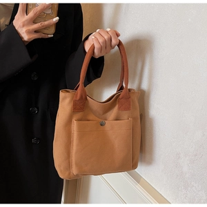 Bolso tote de lona marrón caramelo con bolsillo delantero y hebilla metálica