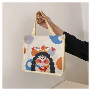 Detail of canvas tote bag featuring colorful dots and cute cartoon girl illustration