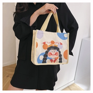 Close-up of canvas handbag with cute cartoon girl print and yellow strap handles