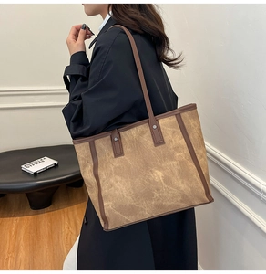 Detailansicht der großen Tote-Bag mit Vintage-Textur und braunen Trägern an der Schulter
