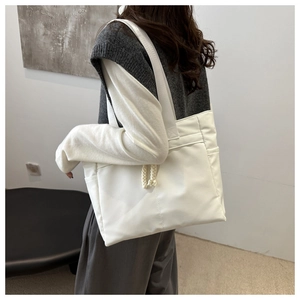 Grande borsa tote bianca minimalista con tasche laterali e dettaglio di nodo in corda