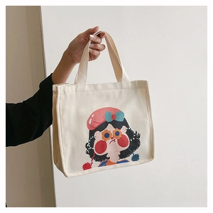 Close-up of a cream canvas tote bag featuring a cute cartoon girl with a pink beret