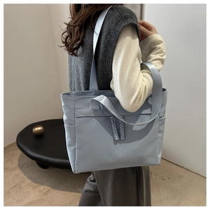 Dettaglio borsa tote in nylon con cerniera in corda intrecciata e tasche laterali