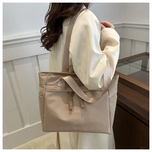 Dettaglio borsa tote beige con doppie tracolle e tasca laterale per pendolari