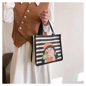 Detail of canvas tote bag with black stripes and colorful cartoon girl illustration