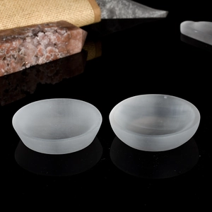 Two natural selenite crystal bowls on black reflective background for home decor