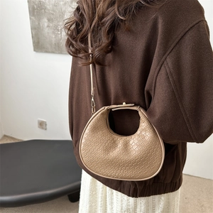 Minimalist beige woven crescent shoulder bag with golden metal hardware and strap
