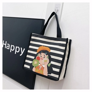 Detail of canvas tote bag featuring black and white stripes and a cartoon girl illustration