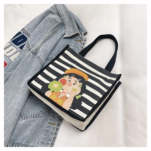 Detail of canvas tote bag featuring stripe patterns and a colorful cartoon girl print
