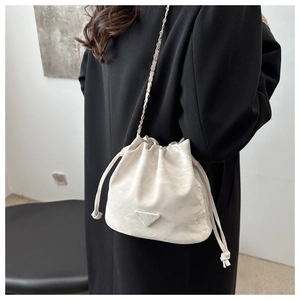 Detail of white marble textured bucket bag with fashion plaque and chain strap