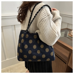 Detailed view of the vintage polka dot tote bag with woven rope handle on a female model