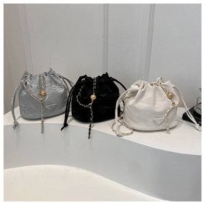 Retro drawstring bucket bags in silver, black and white with chain straps and metal logos
