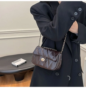 Close-up of vintage dark brown quilted bag with gold twist lock and chain strap