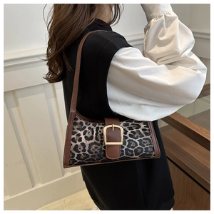 Detailed view of leopard print shoulder bag with brown leather trim and gold buckle