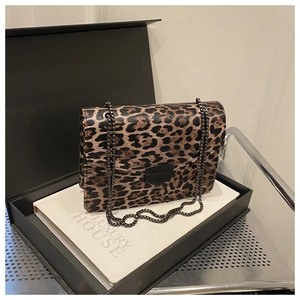 Chic leopard print crossbody bag with metallic chain strap on a luxury gift box