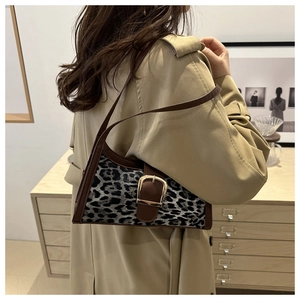 Dettaglio borsa sottobraccio leopardata con finiture in pelle e fibbia dorata chic