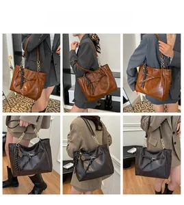 Detail of vintage oil wax leather tote showing chain strap and elegant tassel charm