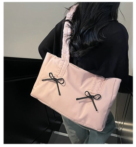 Détail du cabas plissé rose avec des nœuds noirs et une poignée à volants